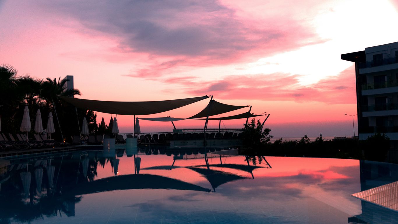 brown wooden gazebo on body of water during sunset
