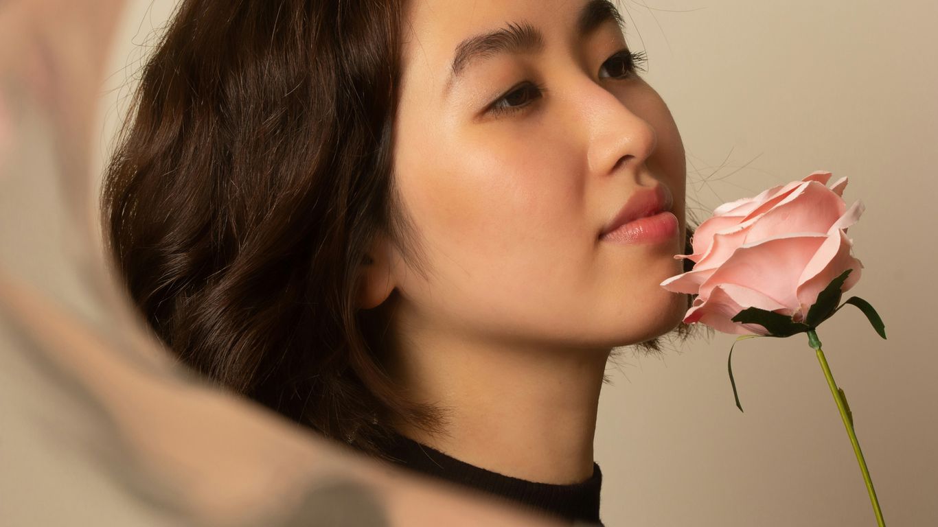 woman in black crew neck shirt holding white flower