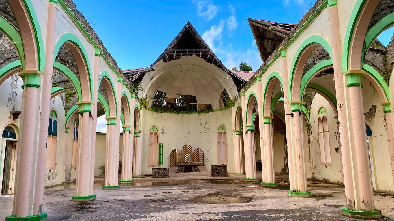 an old building with arches and a clock on the wall