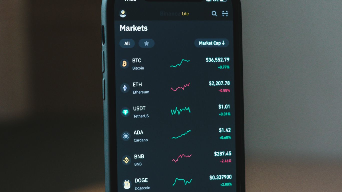 Smartphone displaying cryptocurrency market data and charts.