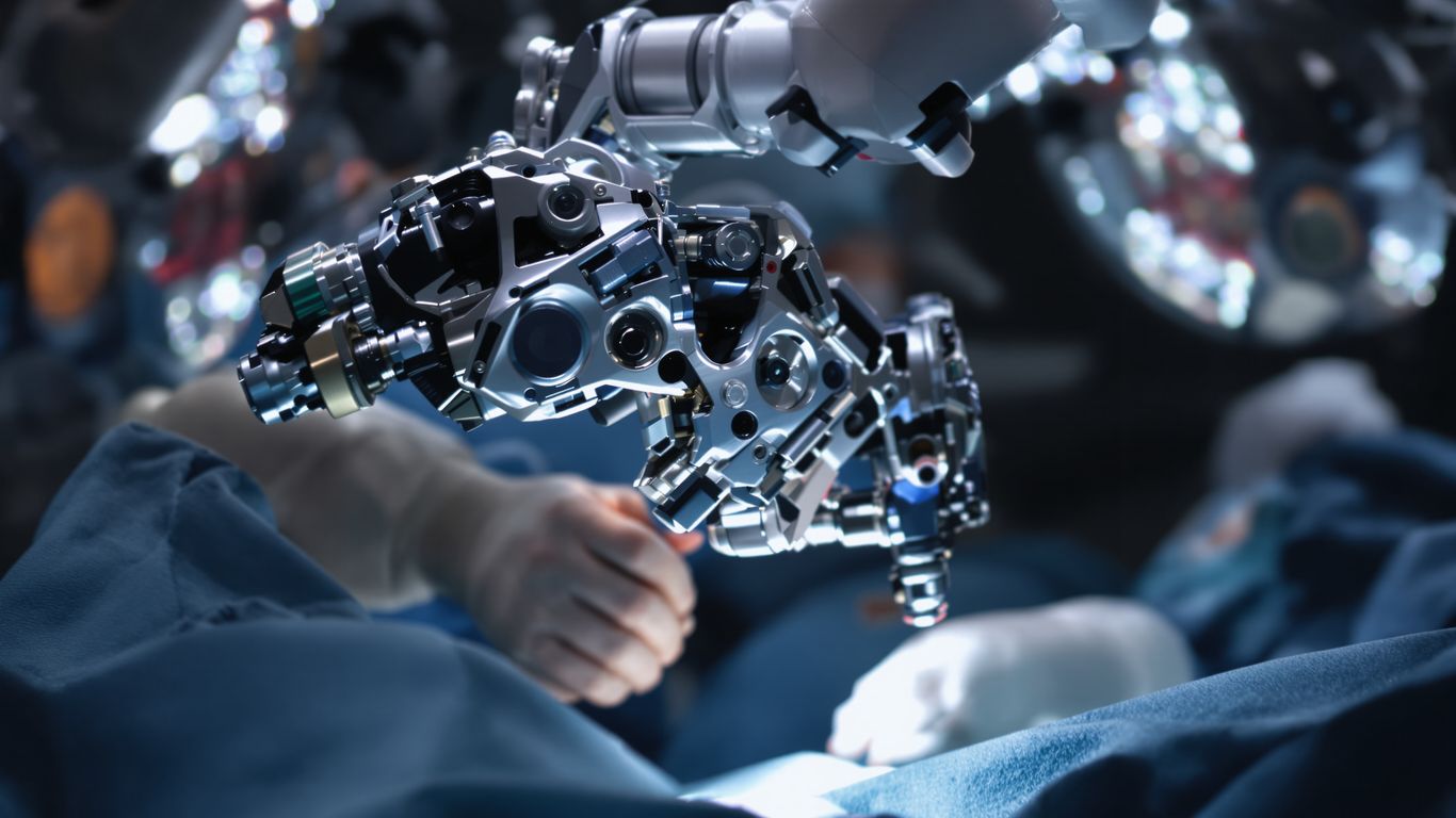 Manos de cirujano operando con brazo robótico.