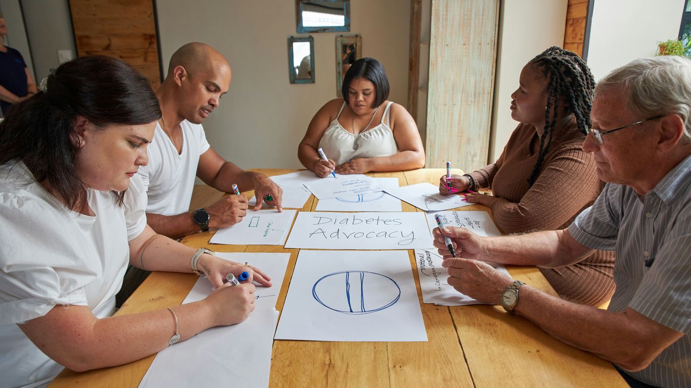 People are drawing on paper during a meeting.