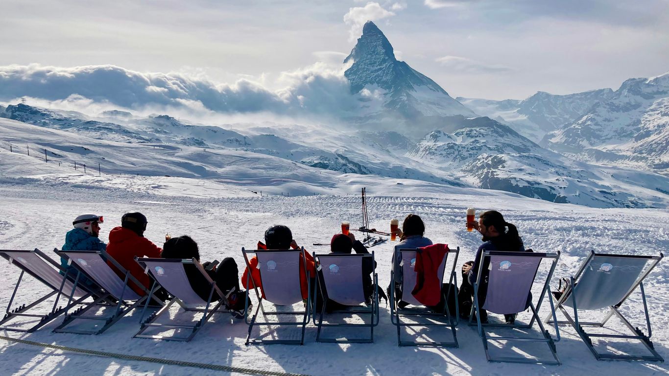 a group of people sitting in chairs on a snowy mountain