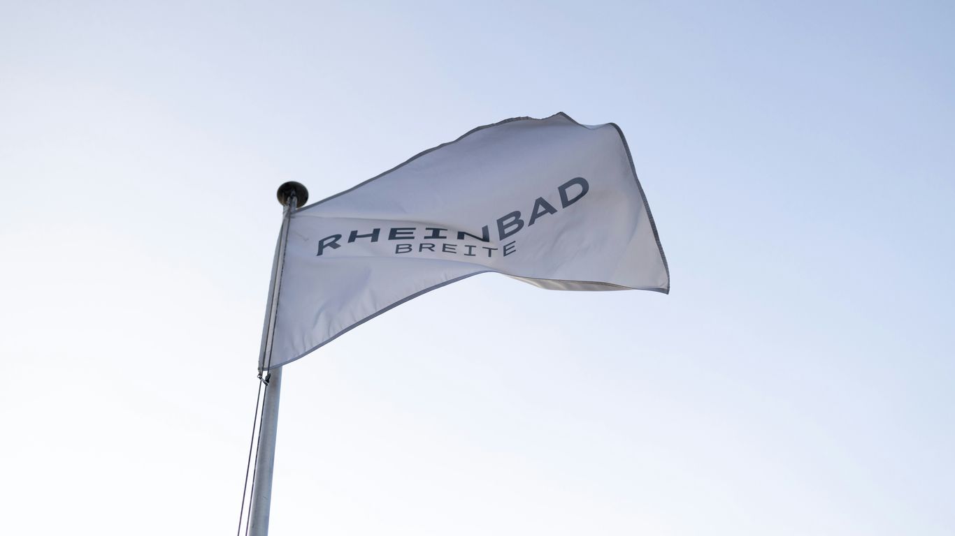 A white flag flying in the wind with a blue sky in the background