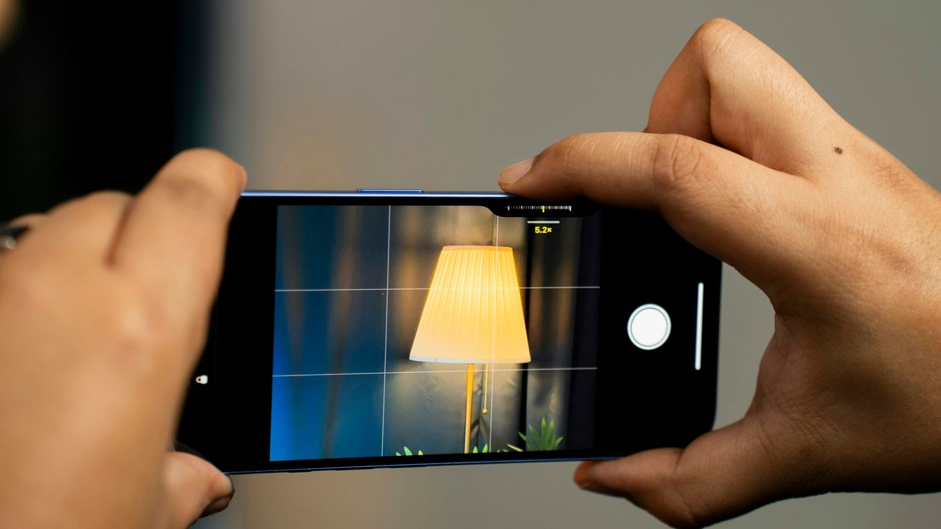 A person taking a picture of a lamp on a cell phone