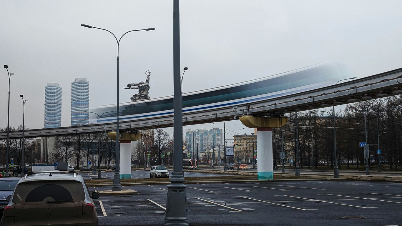 A monorail train speeds along an elevated track.