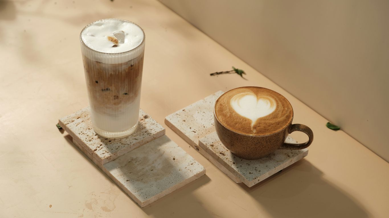 a cup of coffee and a teapot on a table