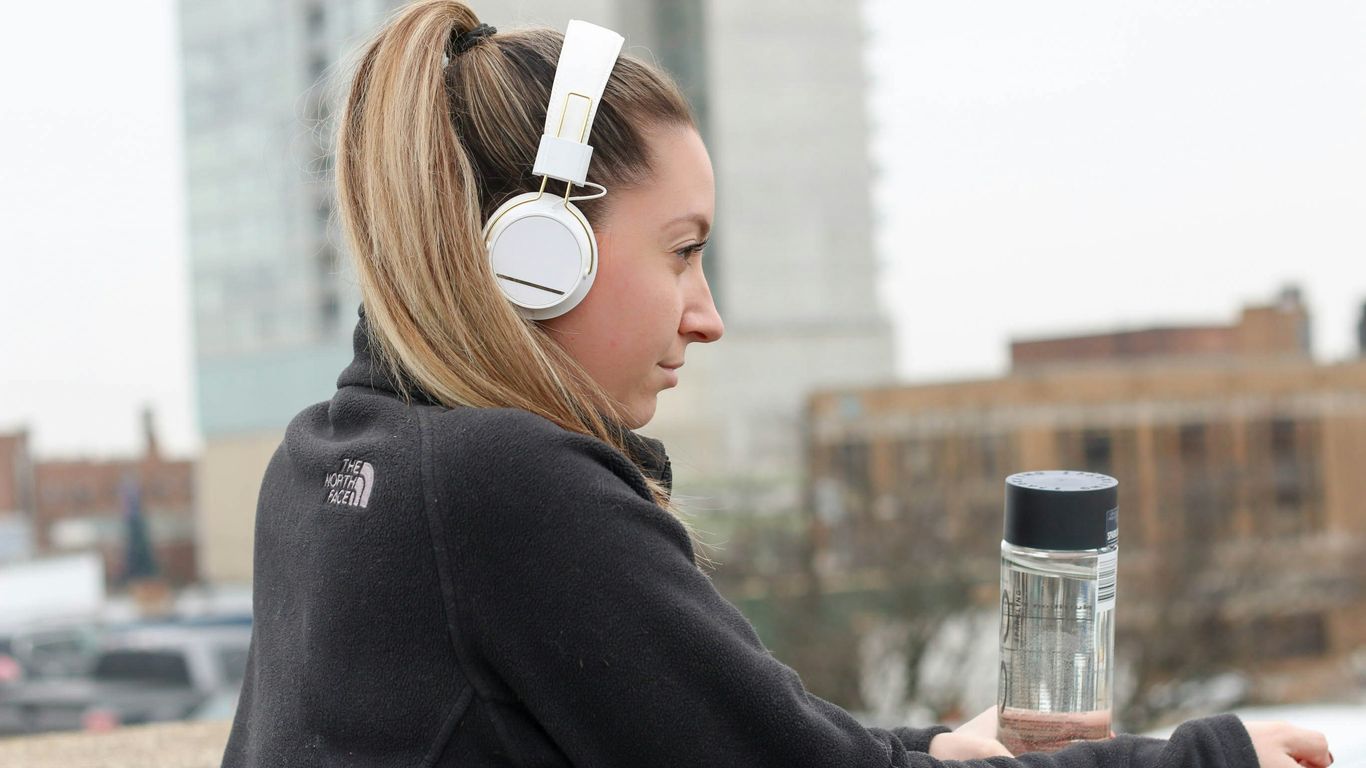 woman wearing black The North Face jacket and white headphones