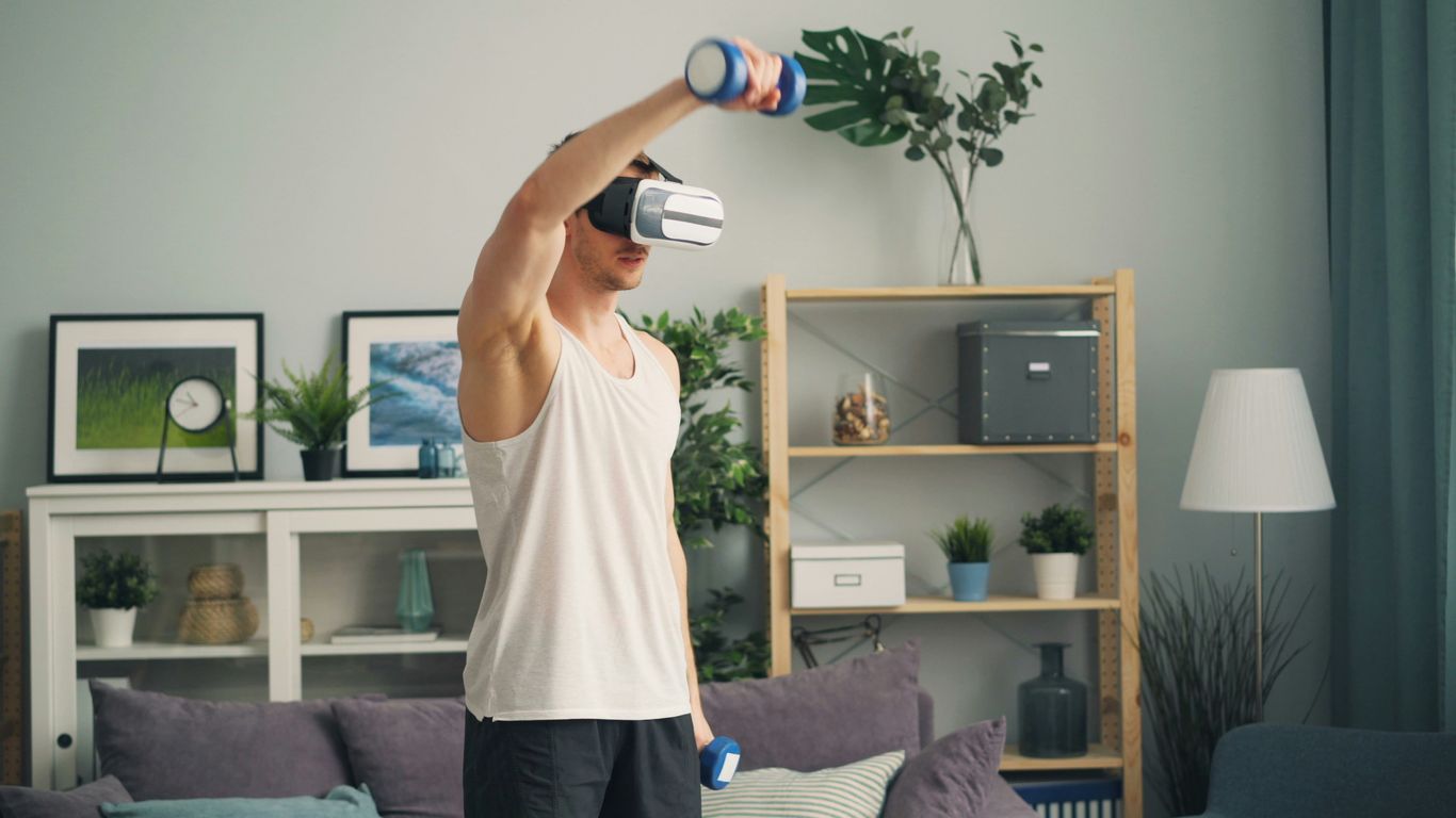 a man in a living room holding a pair of virtual glasses