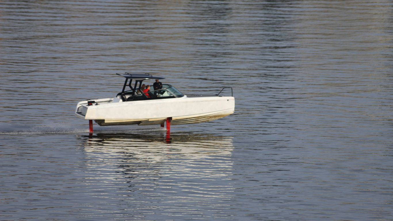 A small white boat floating on top of a lake
