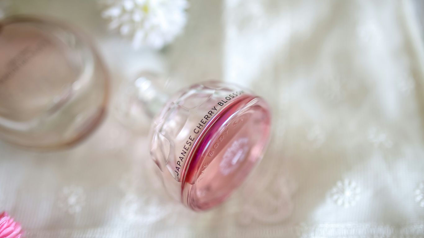 clear Japanese Cherry Blossom fragrance bottle on white textile