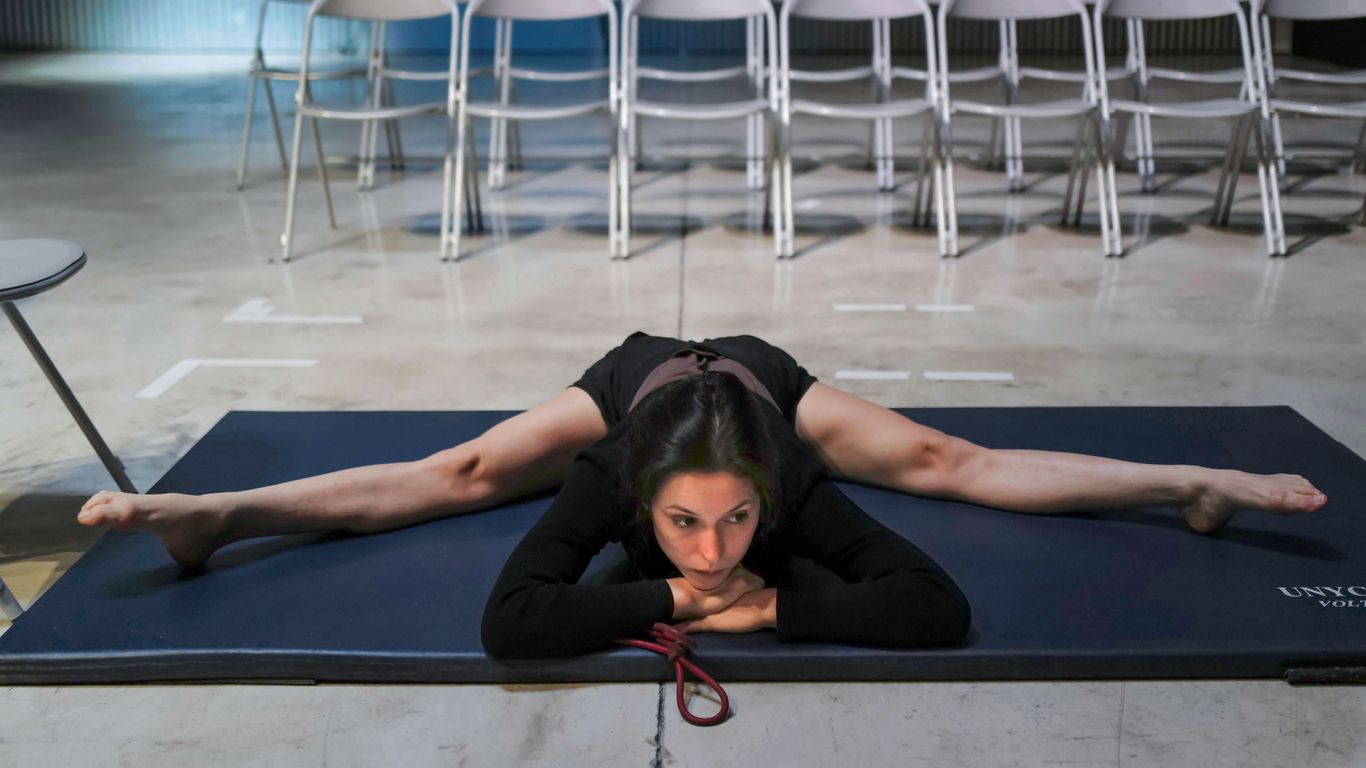 woman in black shirt lying on blue and white pool bed
