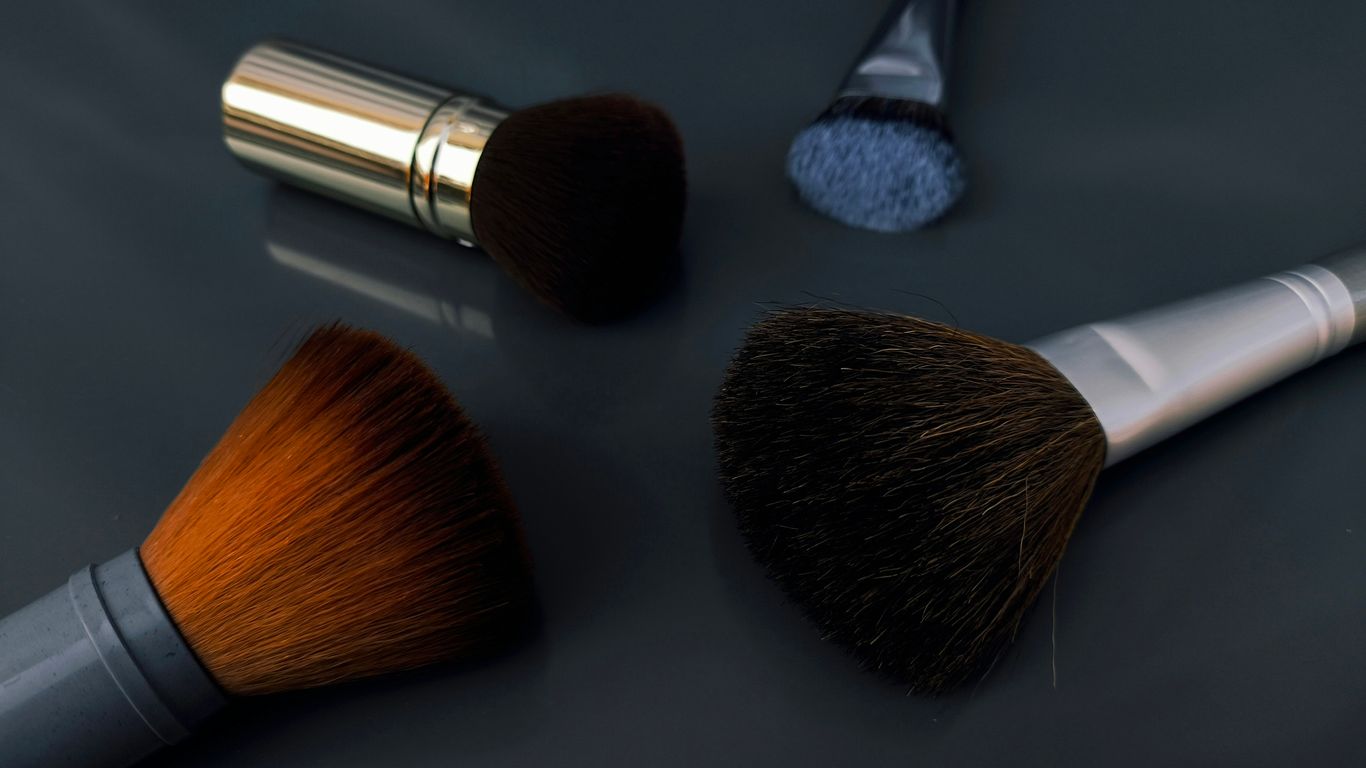 A close up of three makeup brushes on a table