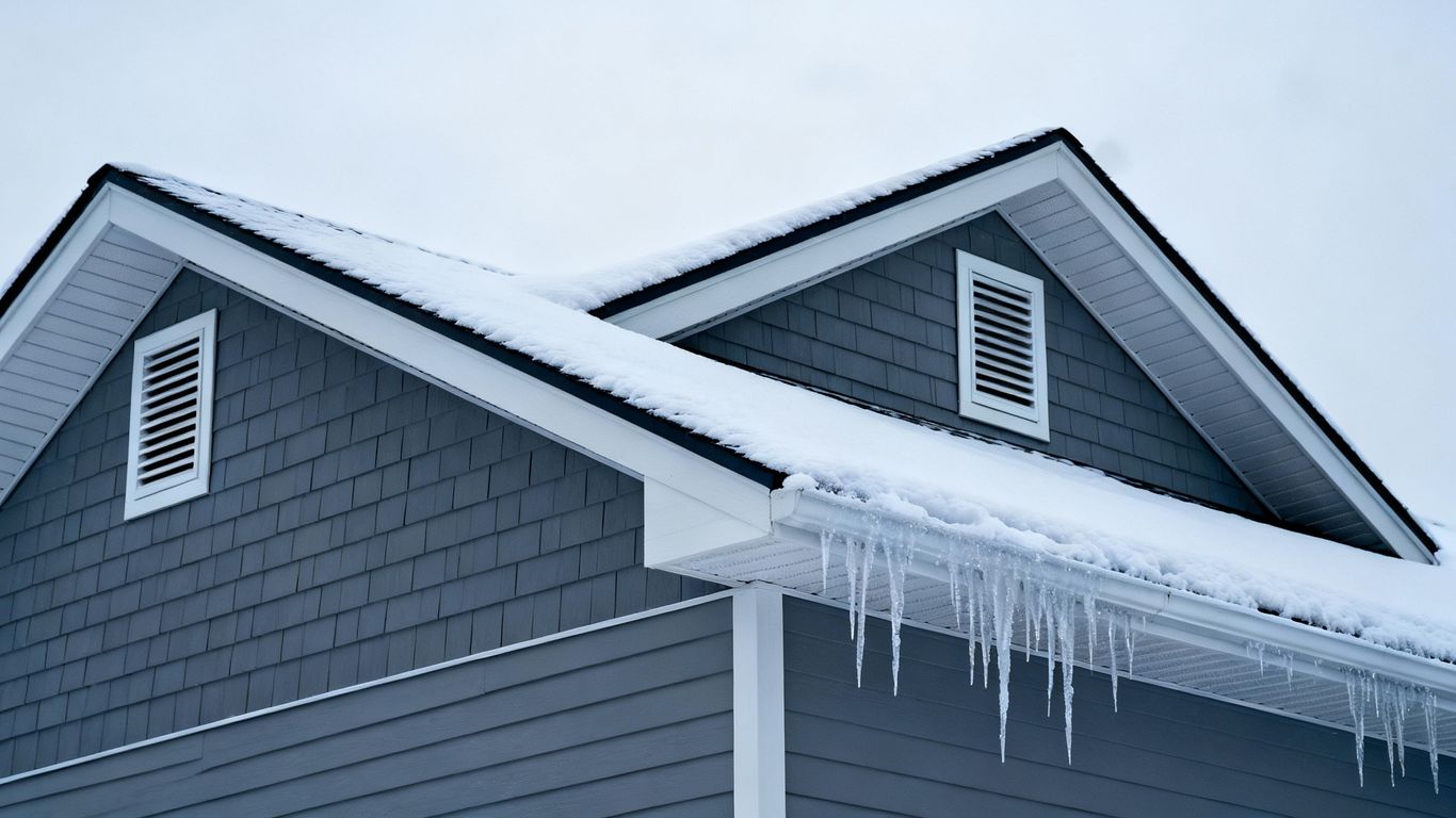 Snowy roof with visible ventilation openings in winter.