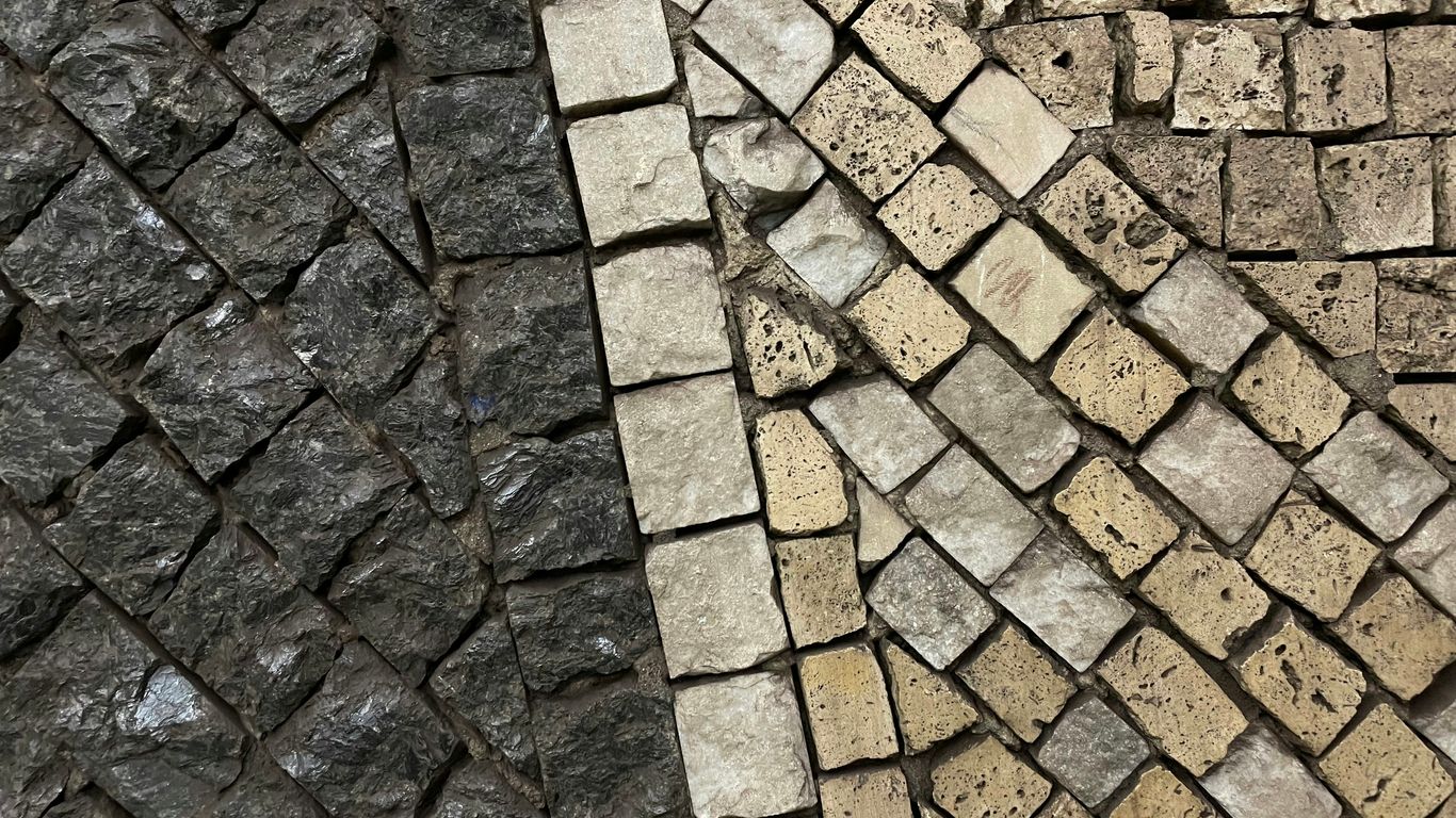 a close up of a brick wall and a stone floor