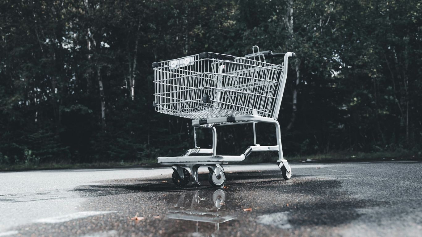 A shopping cart sitting in the middle of a parking lot
