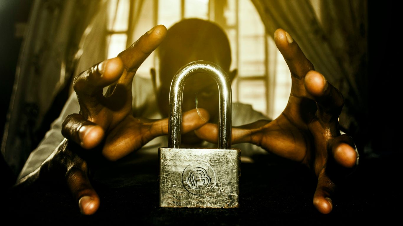 a person holding a padlock in front of a window