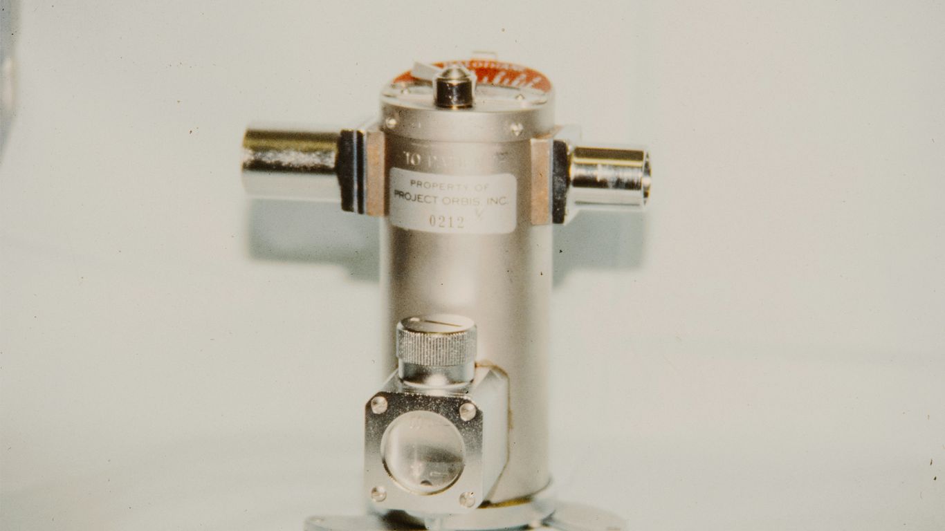 A metallic cylindrical object with two side connectors.