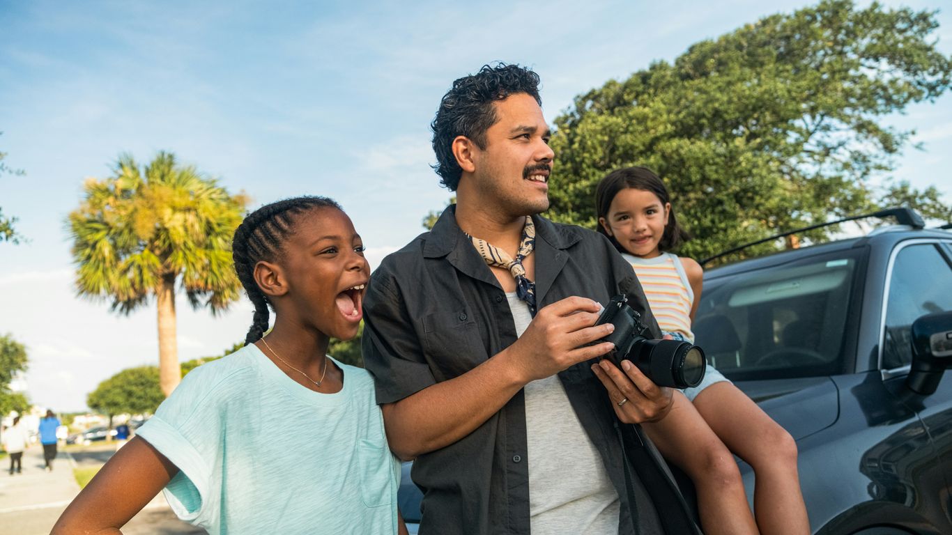 Man with two girls looking away
