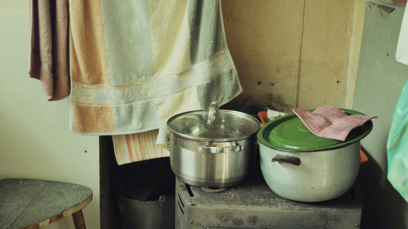 a stove top oven sitting next to a pot on top of a wooden table