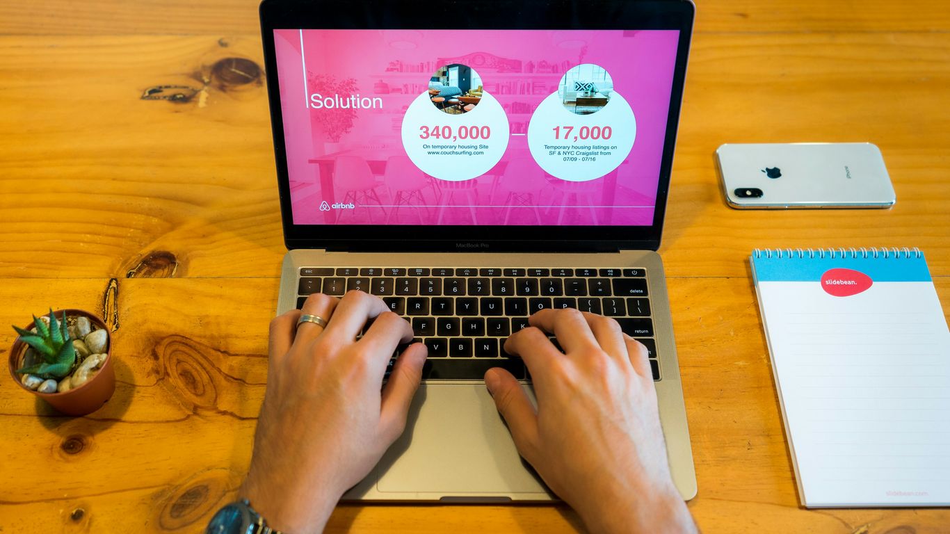 person using macbook pro on brown wooden table