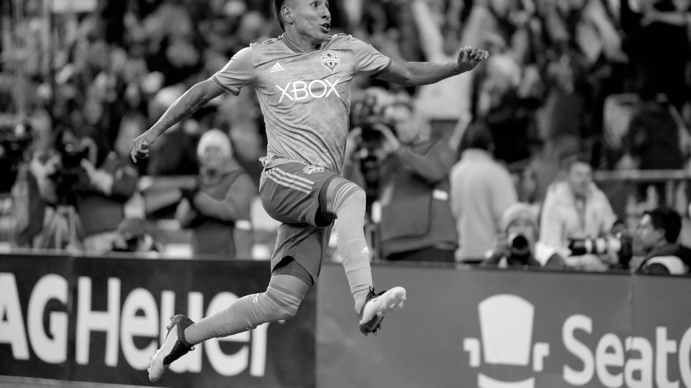 grayscale photo of man playing soccer
