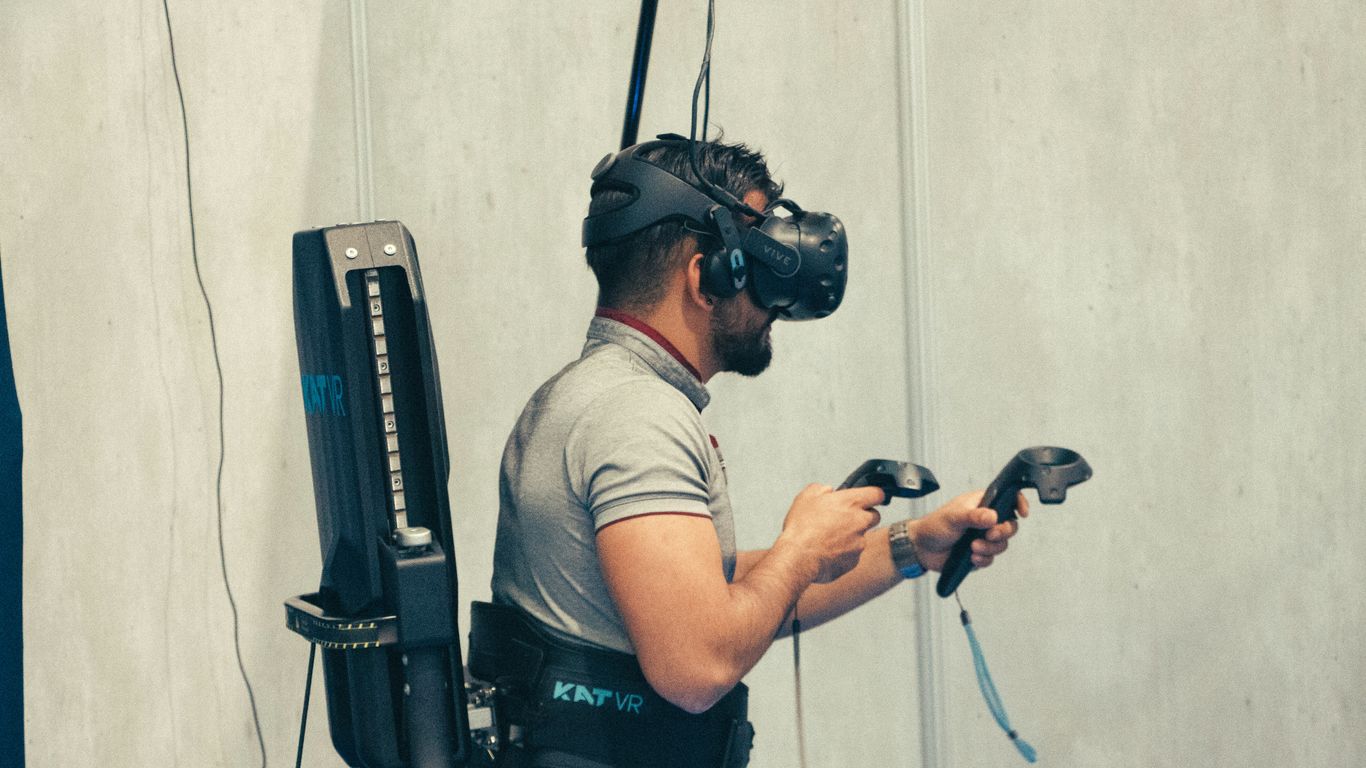 man in gray t-shirt and black pants holding black dslr camera