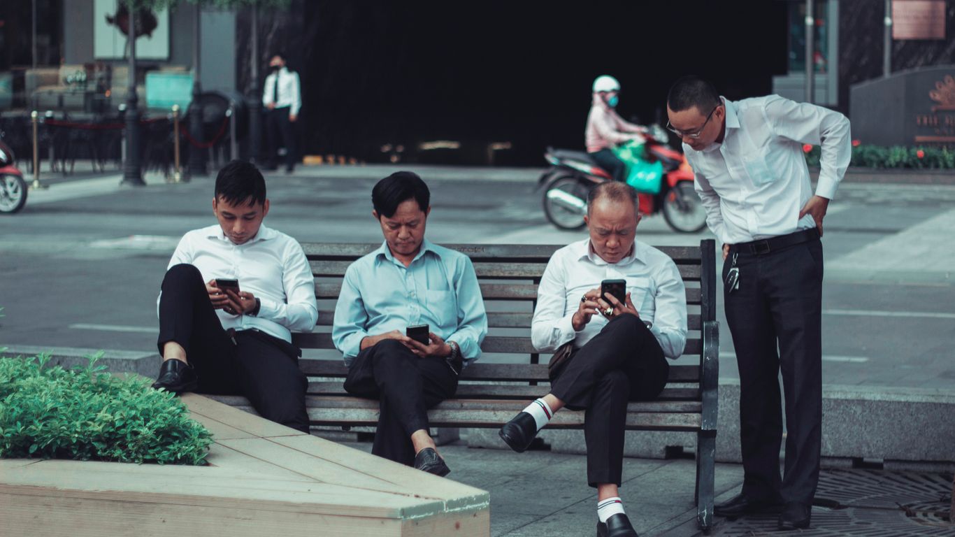 3 men sitting on bench during daytime