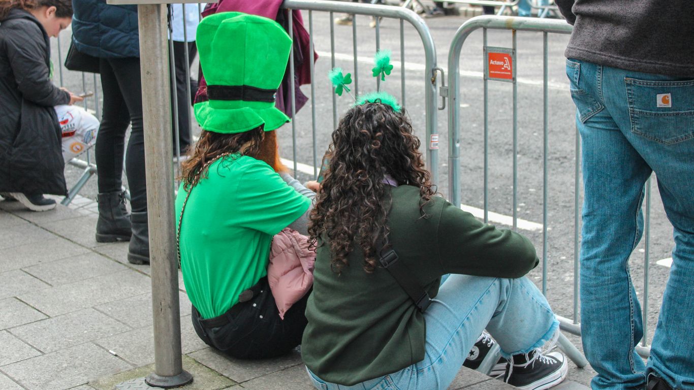 a group of people sitting next to a metal fence