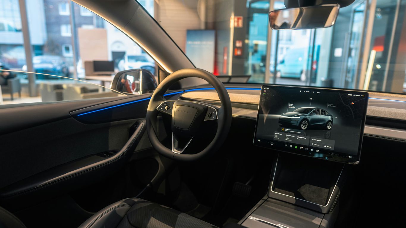 The interior of a car with a laptop on the dashboard
