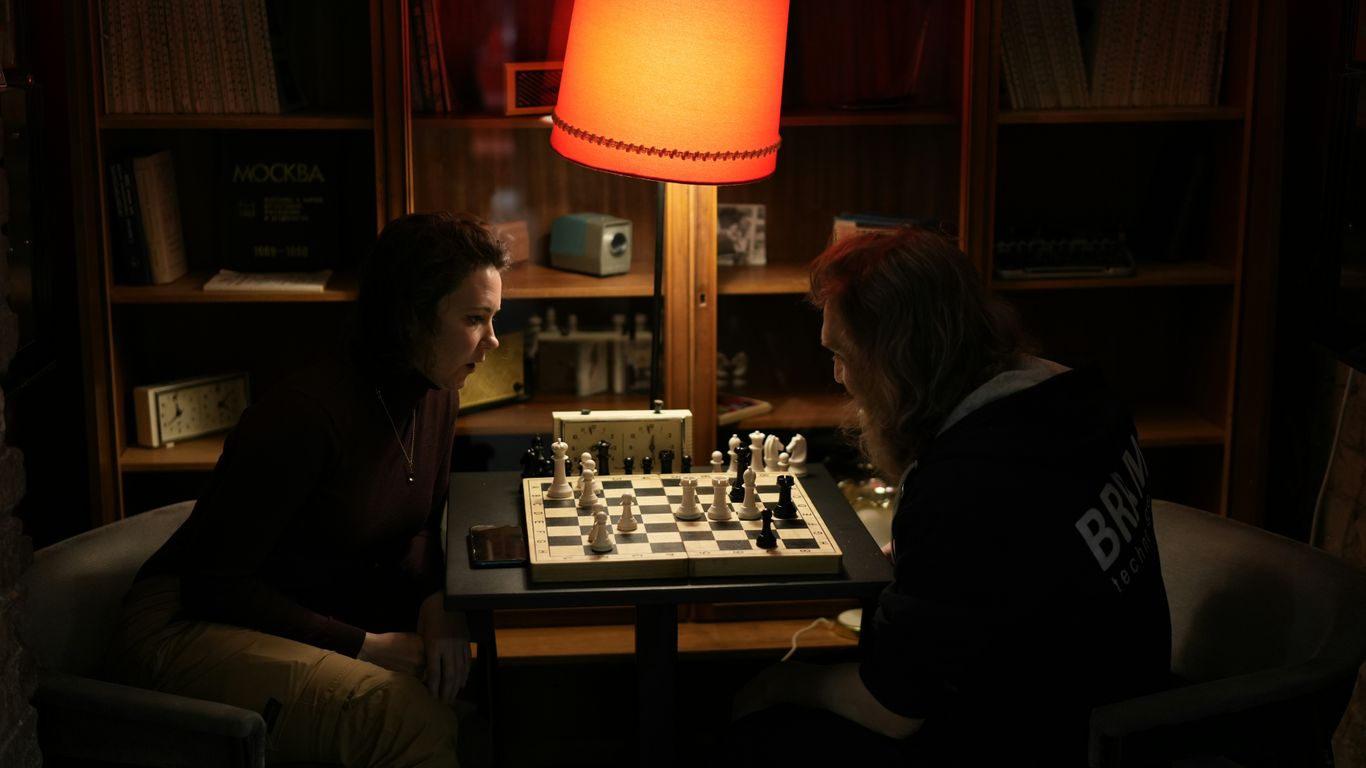 Two people playing chess in a dark room