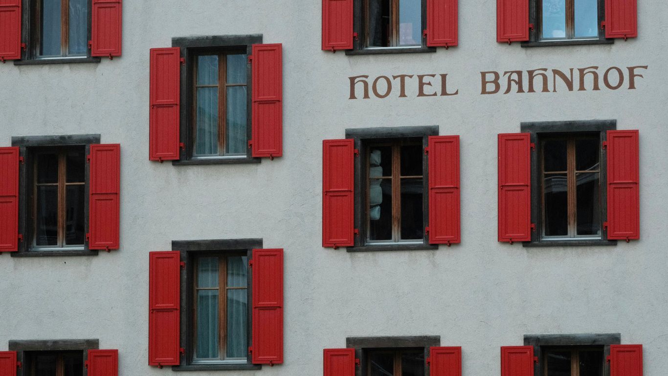 Hotel building facade with red shutters and windows