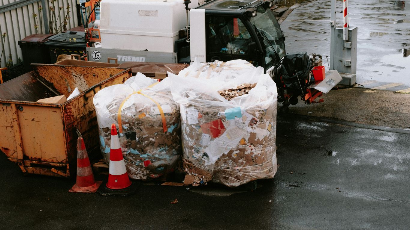 a dump truck parked next to a pile of garbage