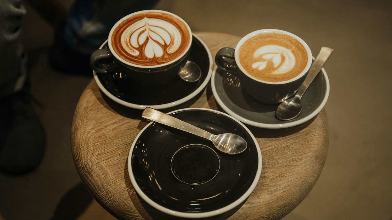 two cups of latte on round brown stool