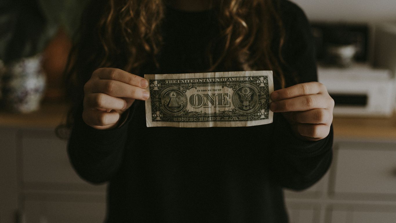 girl holding 1 U.S. dollar banknote