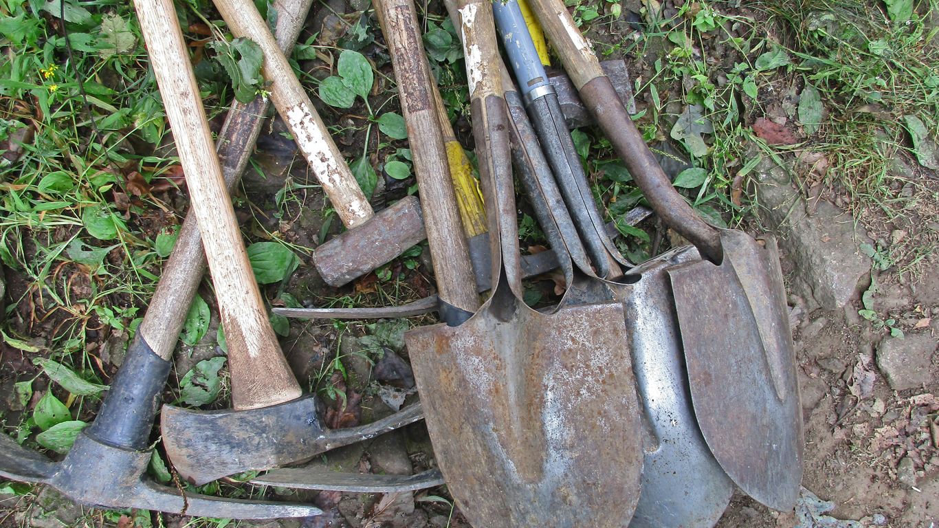 a pile of shovels and forks laying on the ground