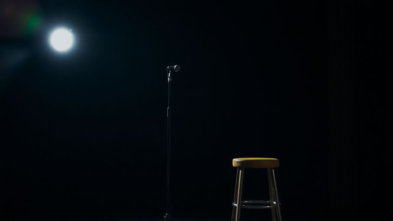 Empty comedy stage with spotlight and microphone.
