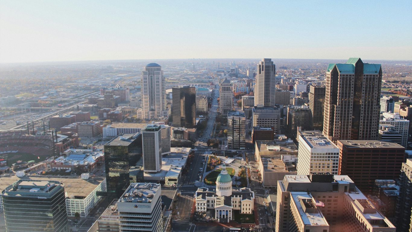 Aerial view of a sprawling St Louis Missouri city skyline at sunrise.