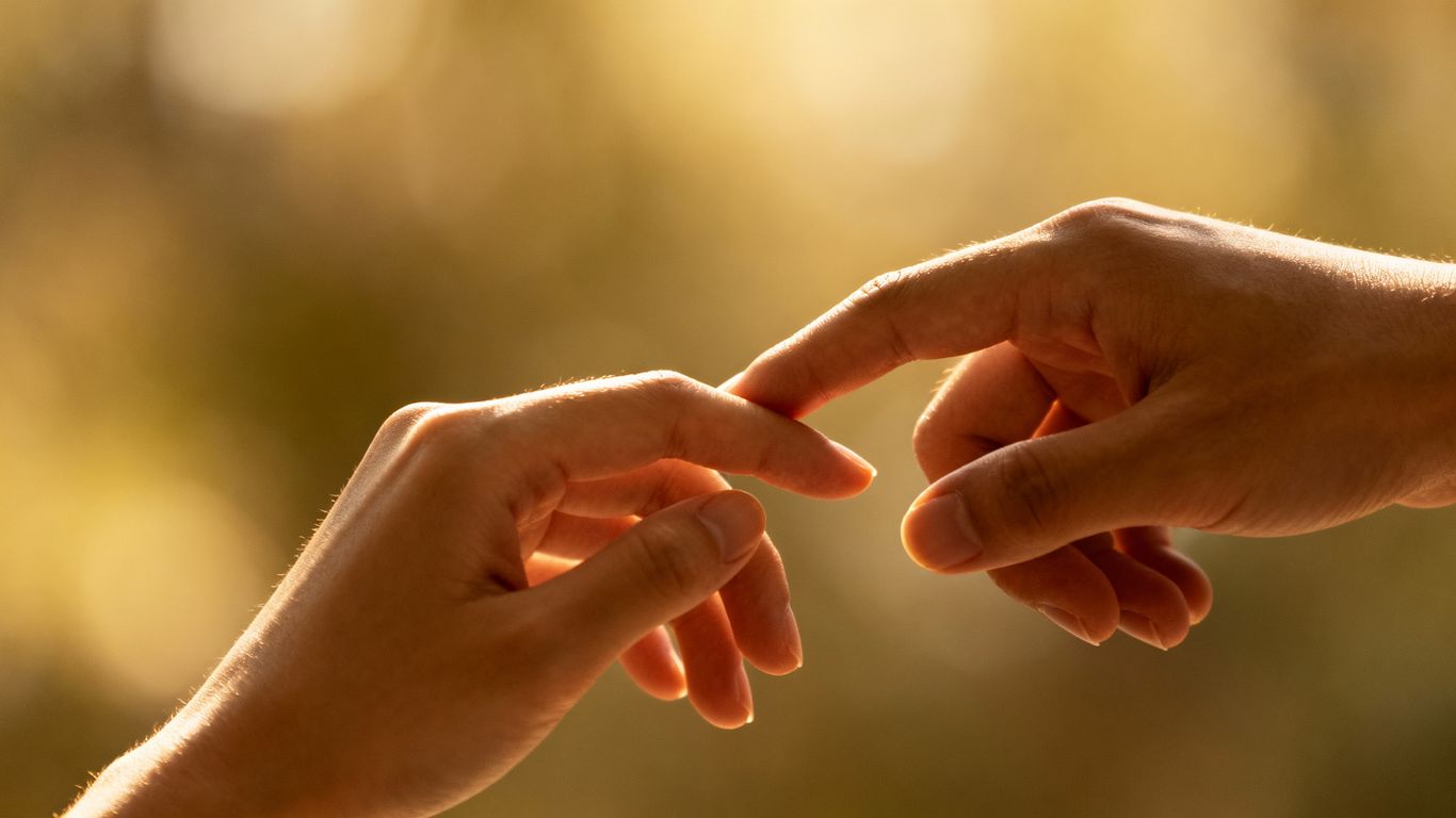 Couple's hands gently touching, symbolizing connection.