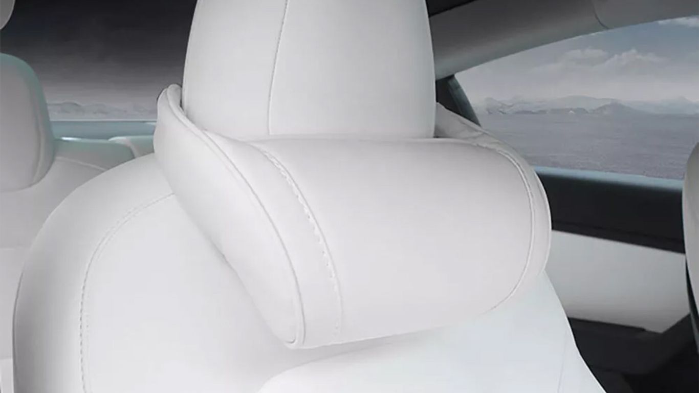 Interior of a car featuring white leather seats and headrest.