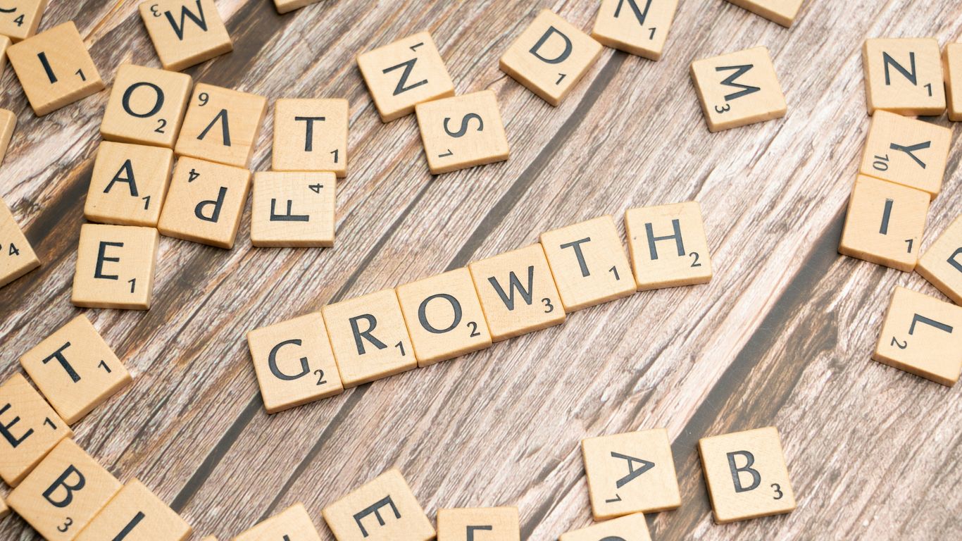 scrabbled letters spelling growth on a wooden surface