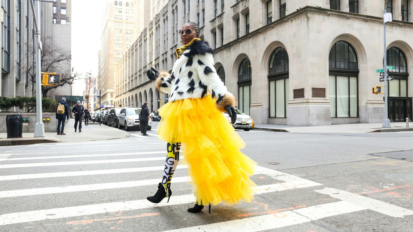 woman wearing yellow and white dress passing on road