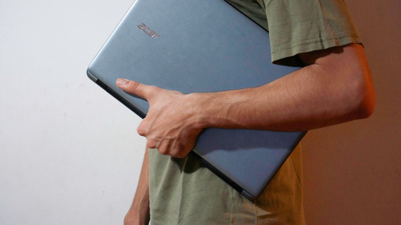 man in green button up shirt holding black tablet computer
