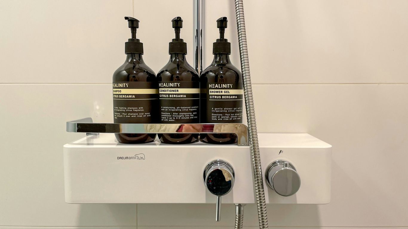 three bottles of shampoo sitting on top of a sink