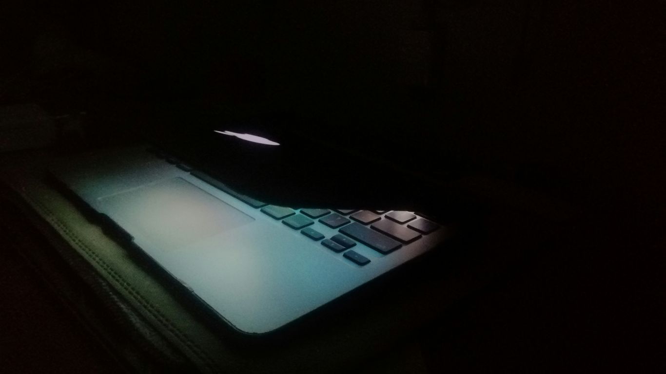a laptop computer lit up in the dark