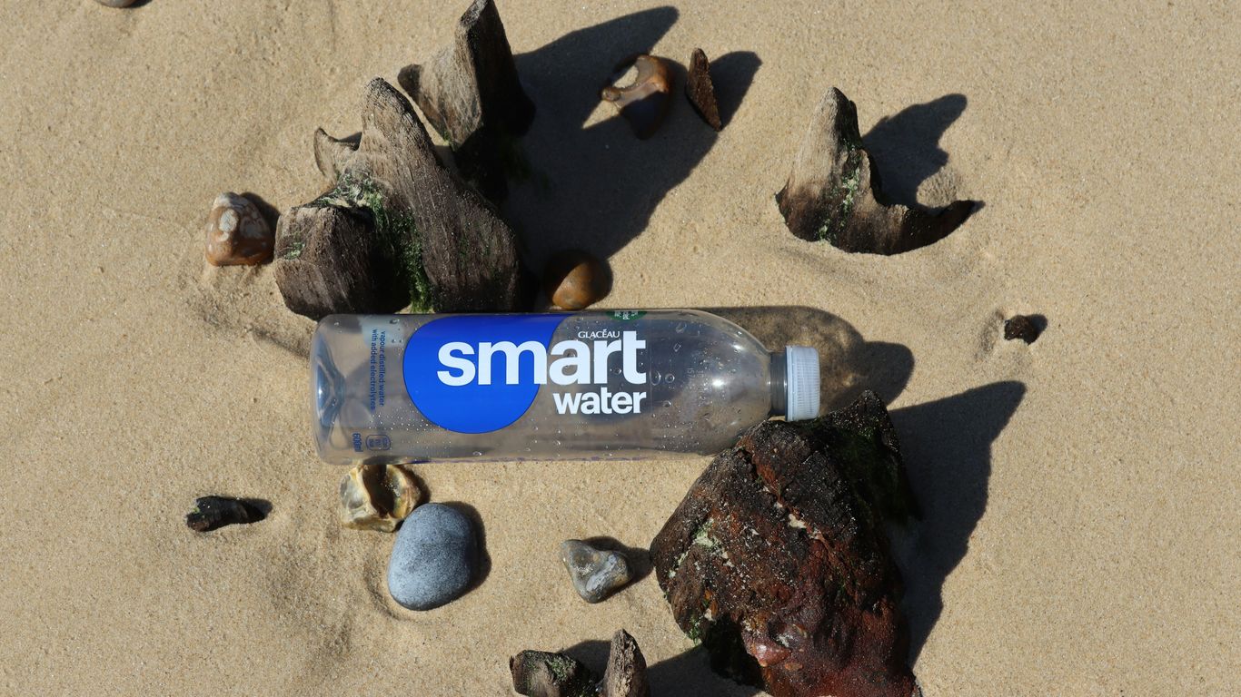 a smart water bottle laying on the sand