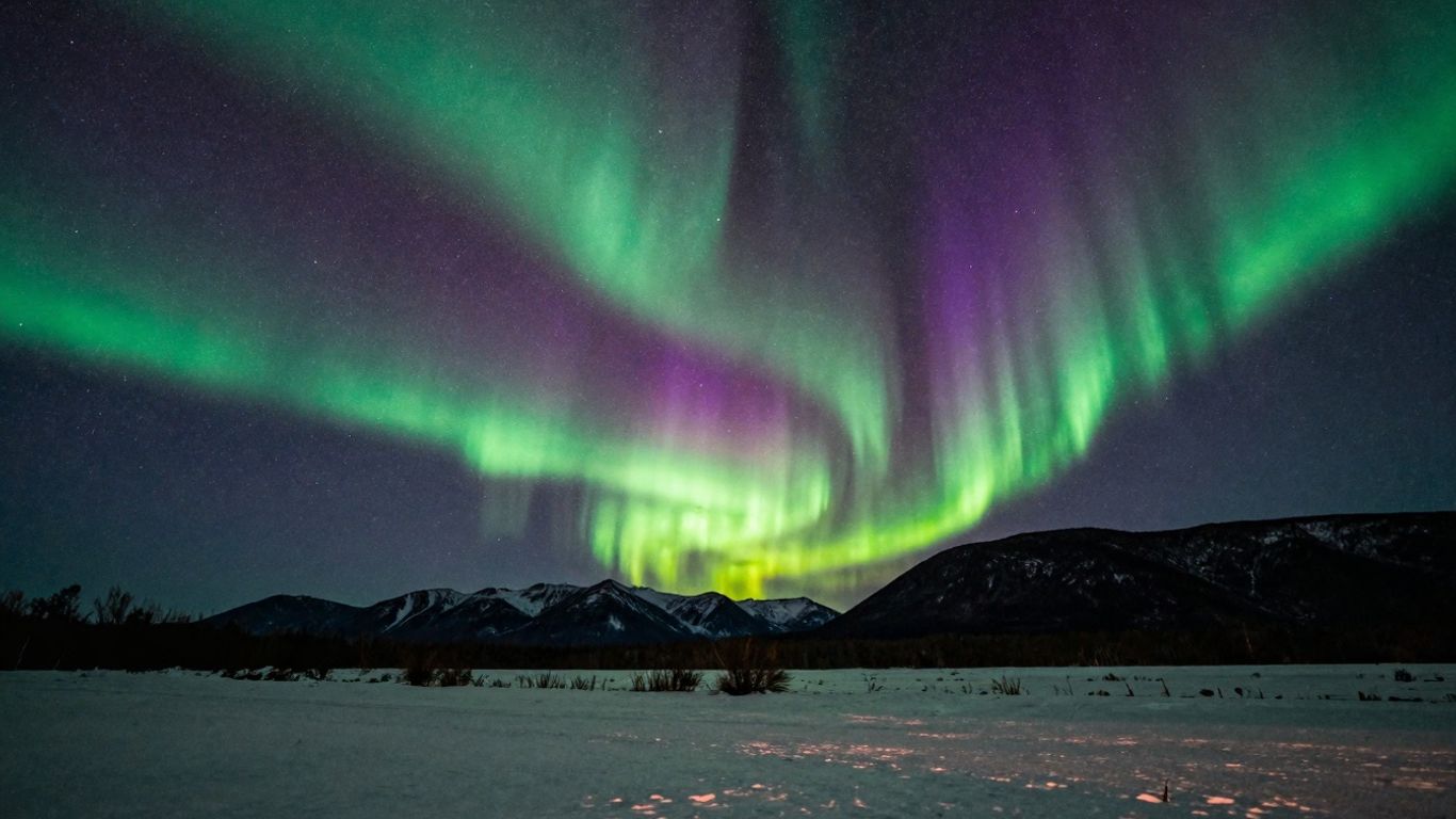 Grüne und violette Südlichter über einer Berglandschaft