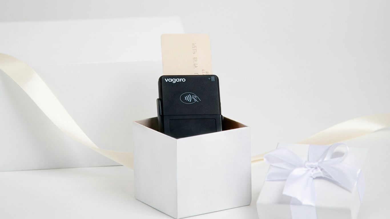 Black device in a white gift box with ribbon
