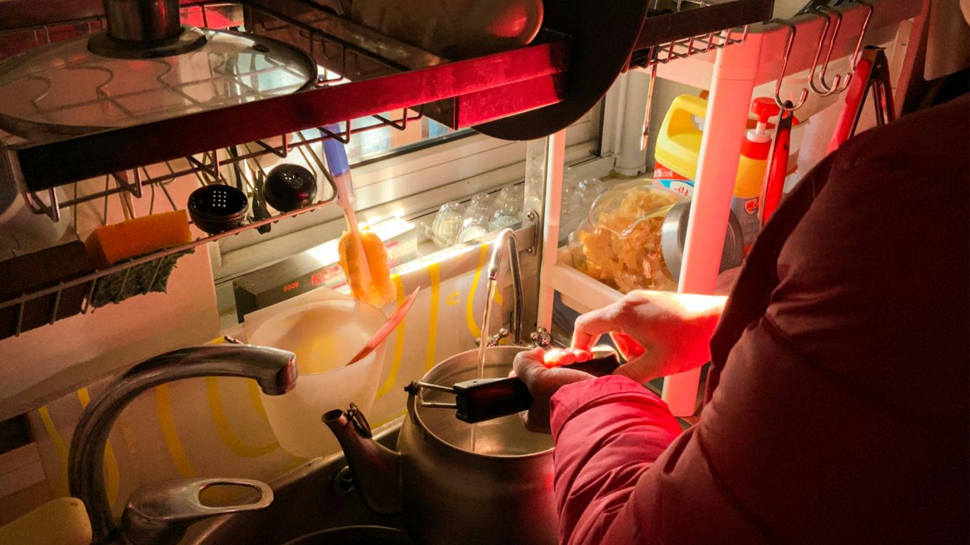 a woman in a red jacket is preparing food in a kitchen