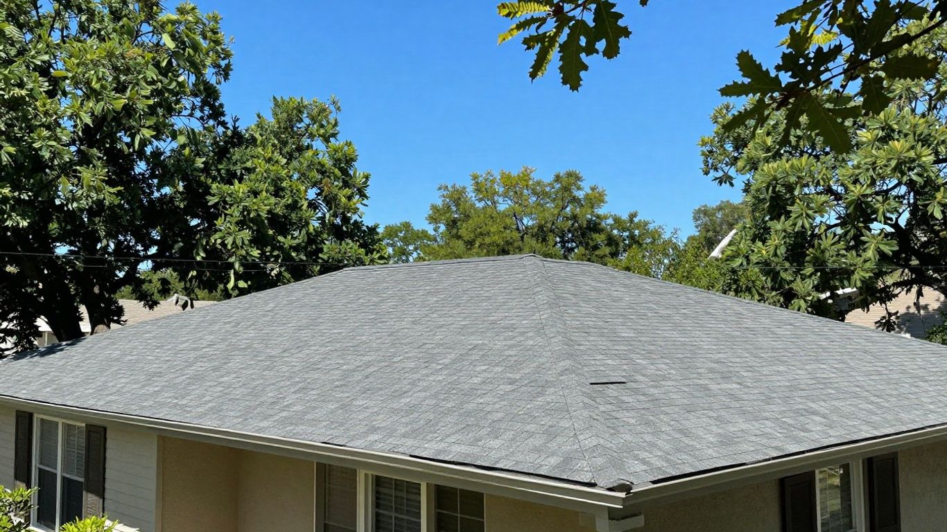 Tolar home roof with clear skies and surrounding trees.